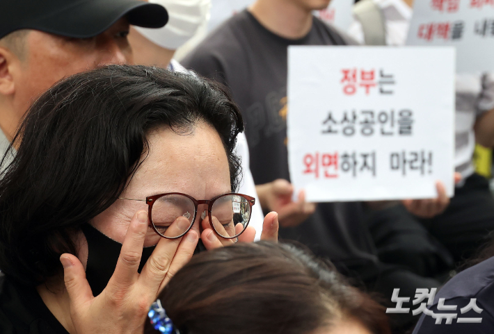 지난달 15일 서울 종로구 청와대 사랑채 앞에서 열린 '홈플러스 사태, 소상공인 생존권 영업권보장 촉구 집회' 에 참가한 한 홈플러스 입점 점주가 눈물을 흘리고 있다. 황진환 기자