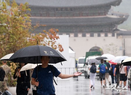 전국 곳곳에 강하고 많은 비가 쏟아지는 31일 서울 종로구 광화문 광장에 우산을 쓴 시민들이 발걸음을 옮기고 있다.