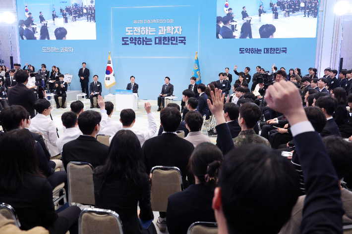 지난 2월 5일 청와대에서 열린 미래 과학자와의 대화 '도전하는 과학자, 도약하는 대한민국'에서 참석자들이 이재명 대통령을 향해 발언권을 요청하며 손을 들고 있다. 연합뉴스