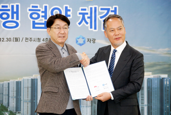 우범기 당시 전주시장과 전은수 자광 대표이사(왼쪽부터)가 2024년 12월 30일 전주 옛 대한방직 부지 개발 사업에 대한 협약서를 들고 기념촬영을 하고 있다. 전주시 제공