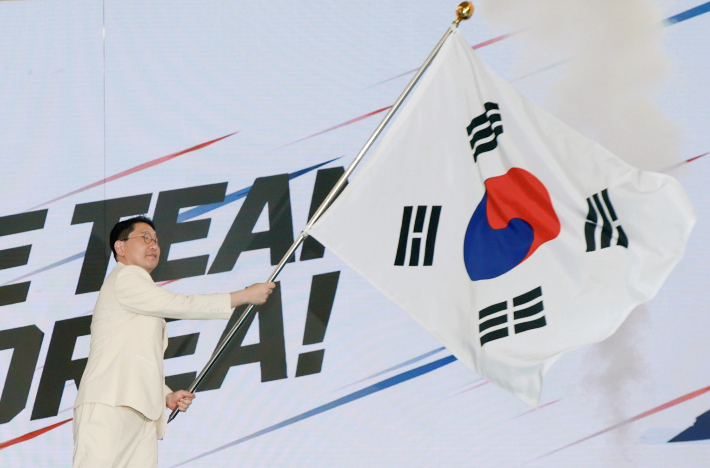 이상현 2026 아이치·나고야 아시안게임 선수단장이 3일 충북 진천선수촌에서 열린 결단식에서 유승민 대한체육회장으로부터 단기를 받아 흔들고 있다. 연합뉴스