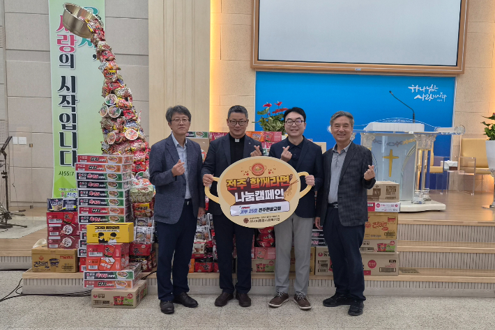 전주현암교회와 선너머종합사회복지관 관계자들이 '전주함께라면' 나눔 캠페인 팻말을 들고 기념촬영을 하고 있다. 전주현암교회 제공