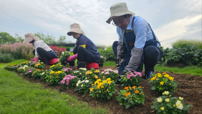 손훈모 시장(우측)이 정원사들과 함께 꽃을 심고 있다. 순천시 제공
