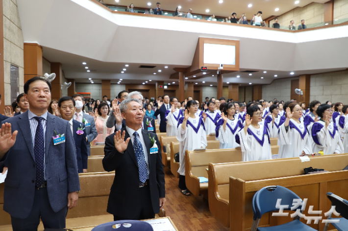 2부 위임예식에서 위임국장 손병렬 목사, 교우들의 서약 순서. 김일현 기자
