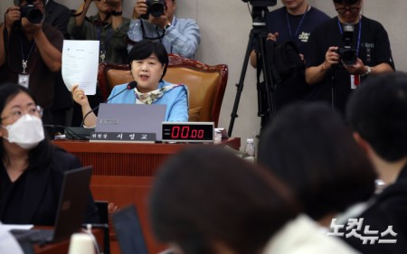 서영교 국회 법제사법위원회 위원장이 9일 국회에서 열린 법사위 전체회의에서 김승원 법무부 장관 후보자에 대한 불기소 처분 결정서를 들어보이고 있다.
