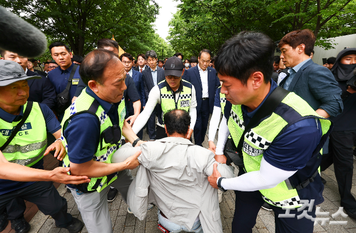 윤상현 국조특위 위원장과 6·3 지방선거 투표용지 부족 사태를 조사 중인 국회 국정조사특별위원회 위원들이 2일 서울 송파구 올림픽공원 내 개표소 내부로 이동하는 도중 한 시위 참가자가 앞으로 달려들고 있다. 국회사진기자단