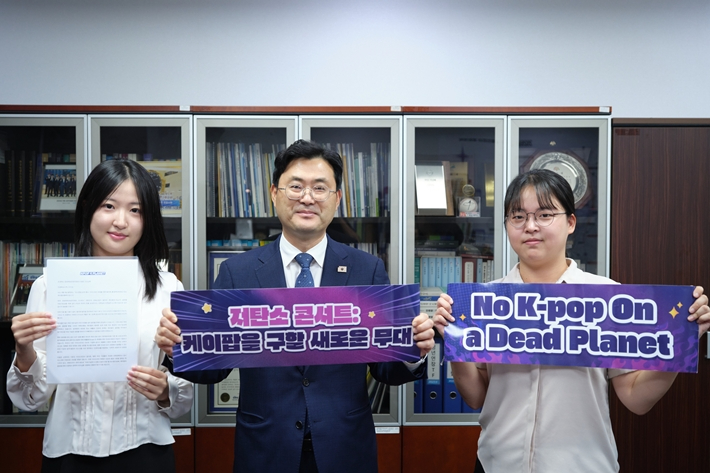 케이팝포플래닛은 지난 8일 서울 여의도 국회의원회관 제6간담회실에서 '탄소중립 공연 행사 가이드라인 제정을 위한 협의체' 출범식과 정책토론회를 열었다. 국회 문체위 간사를 맡은 더불어민주당 이정문 의원(가운데)이 케이팝포플래닛 활동가와 함께 슬로건을 든 모습. 케이팝포플래닛 제공