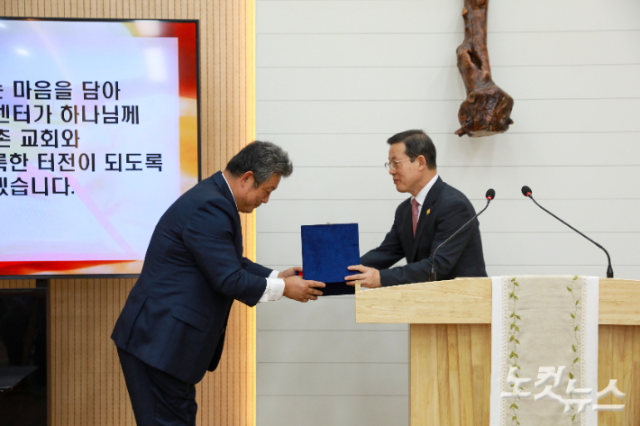 총회장 이종화 목사(오른쪽)가 기독교농촌개발원장 김성주 목사(왼쪽)에게 선교센터 열쇠를 전달하고 있다. 최화랑 기자