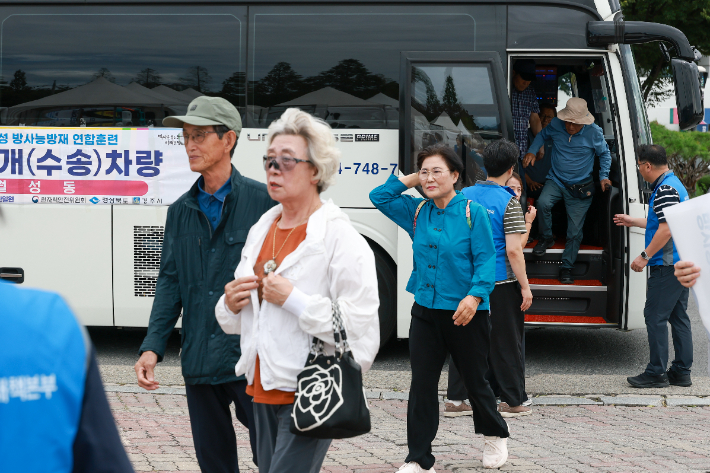 '2026년 월성 방사능방재 연합훈련'에 참여한 주민들이 주민소개 훈련을 위해 수송차량에서 내려 구호소로 이동하고 있다. 경주시 제공