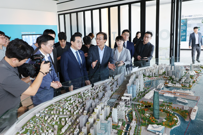 전재수 부산시장이 부산항 북항재개발홍보관에서 박홍근 기획예산처 장관에게 재개발 사업을 설명하고 있다. 전 시장은 박 장관에게 '북항 돔 아레나' 사업 등에 대한 국비 지원을 당부했다. 부산시 제공