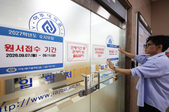 2027학년도 대학 입학 수시모집 원서접수가 시작된 지난 7일 경기도 수원시 아주대학교 입학처에서 관계자가 안내문을 붙이고 있다. 연합뉴스