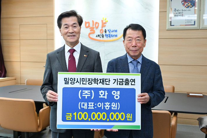 ㈜화영 이홍원 대표이사가 밀양시청 시장실에서 안병구 이사장에게 장학기금 1억원을 전달하고 있다. 밀양시 제공 