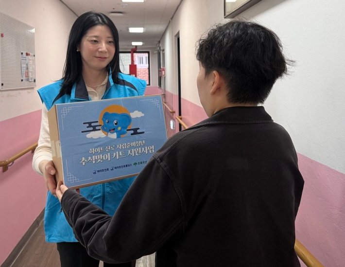 하이트진로홀딩스 관계자가 하이트진로와 하이트진로홀딩스가 추석을 맞아 마련한 힘나는 한가위 '응원 꾸러미'를 자립준비청년에게 전달하고 있다. 하이트진로 제공