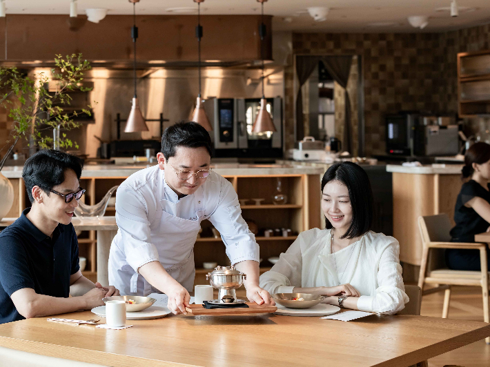 '아사달' 김정환 셰프가 민어만두를 소개하며 신선로를 내려놓고 있다. 한화푸드테크 제공