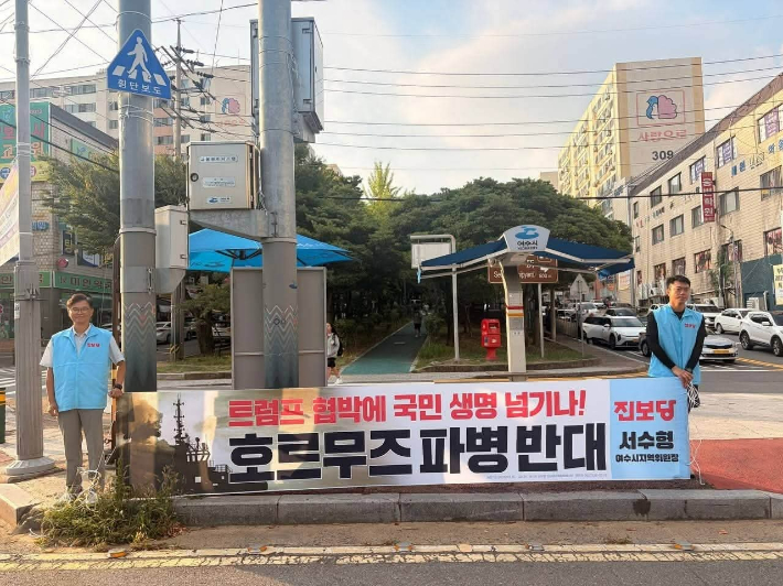 최관식 민주노총 여수시부장(좌측) 등이 부영 3차 앞에서 호르무즈 파병 반대 현수막을 들고 있다. 진보당 제공
