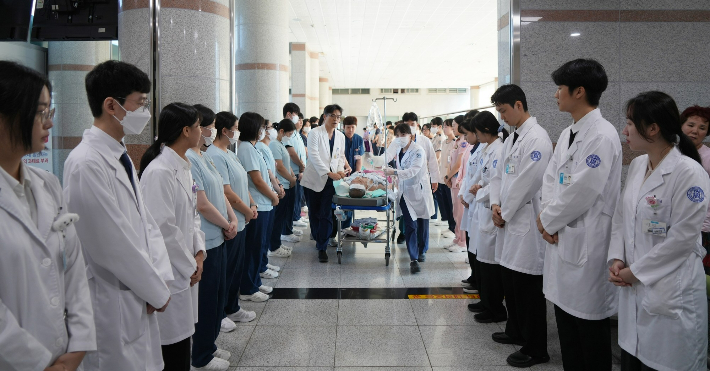 최근 조선대병원 의료진과 직원들이 장기기증 수술을 위해 이동하는 40대 뇌사 기증자를 예우하며 양옆에 서 있다. 기증자는 심장과 간, 양쪽 신장, 양쪽 각막을 기증해 6명에게 새 삶의 기회를 전했다. 조선대학교병원 제공