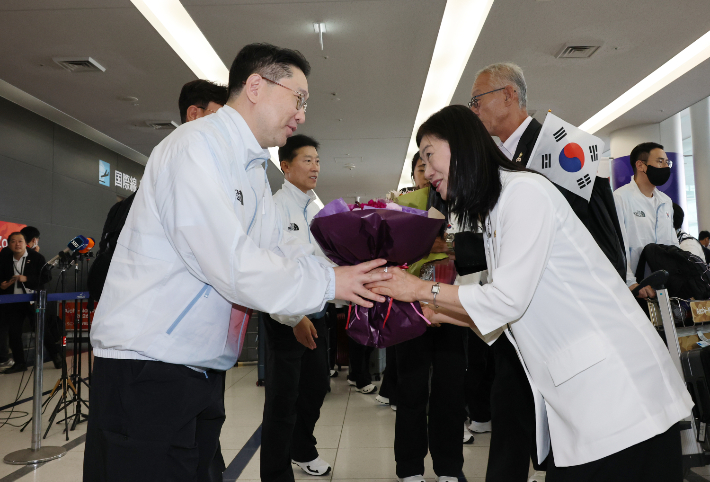 정미애 주나고야 총영사(오른쪽)가 17일 일본 주부국제공항을 통해 입국한 2026 아이치·나고야 아시안게임 한국 선수단 본진을 맞이하며 이상현 선수단장에게 꽃다발을 전달하고 있다. 연합뉴스 
