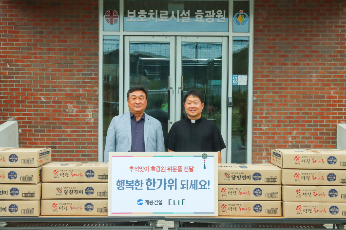 계룡건설 진중길 상무(왼쪽)가 청소년사회복지시설 효광원 김현 원장(오른쪽)에게 위문품을 전달하고 기념 촬영을 진행했다. 계룡건설 제공