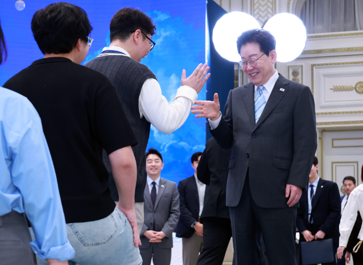 이재명 대통령이 19일 청와대에서 열린 청년의 날 기념식 행사에서 입장하는 청년들과 인사하고 있다. 연합뉴스
