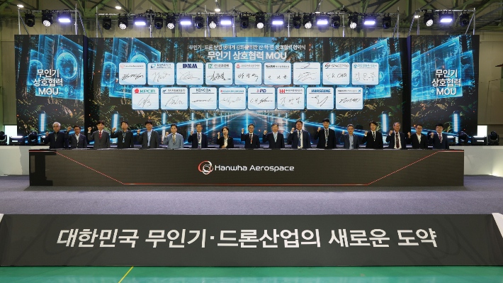 21일 경남 한화에어로스페이스 창원1사업장에서 진행된 '산∙학∙연 상호협력 협약식'에서 국내 무인기·드론 업계 관계자들이 기념사진을 찍고 있다. 한화에어로스페이스 제공