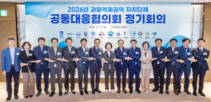 이재준 수원시장(오른쪽 7번째부터), 추미애 경기도지사, 과밀억제권역 자치단체 공동대응협의회 회원 도시 단체장·부단체장들이 손을 맞잡고 있다. 수원시 제공