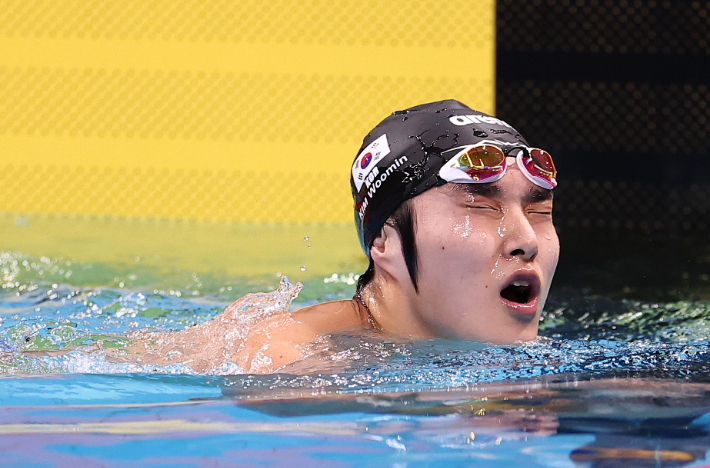 22일 도쿄 아쿠아틱스 센터에서 열린 2026 아이치·나고야 아시안게임 수영 남자 1500m 자유형 결승. 한국 김우민이 결과를 확인한 뒤 아쉬워하고 있다. 연합뉴스