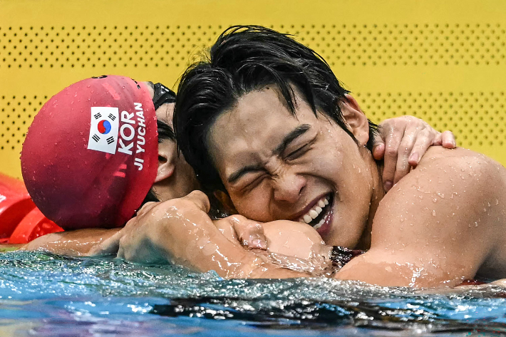 김영범(사진 오른쪽)이 2026 아시안게임 남자 자유형 50ｍ 결승에서 우승한 뒤 한국의 지유찬과 함께 기뻐하고 있다.