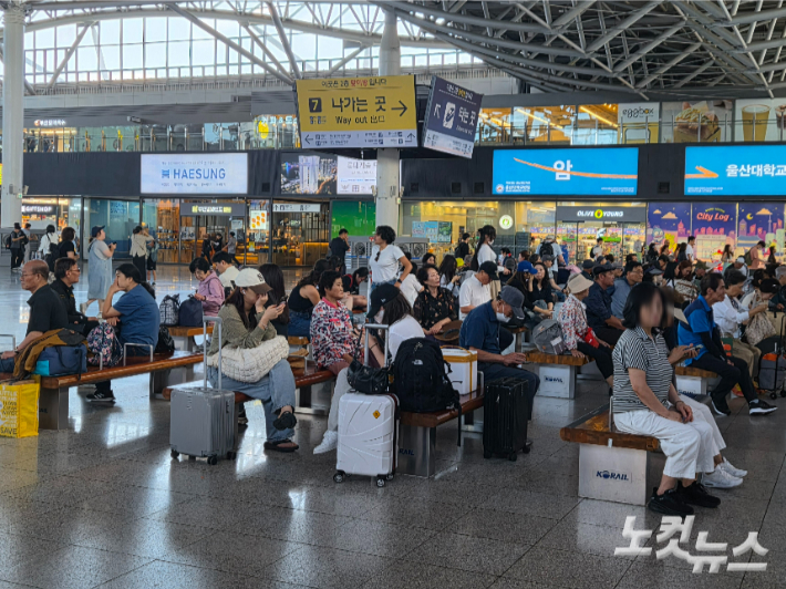 추석 연휴를 하루 앞둔 23일 오전 부산역 대합실에서 짐 가방과 선물 꾸러미 등을 옆에 둔 시민들이 기차를 기다리고 있다. 정혜린 기자