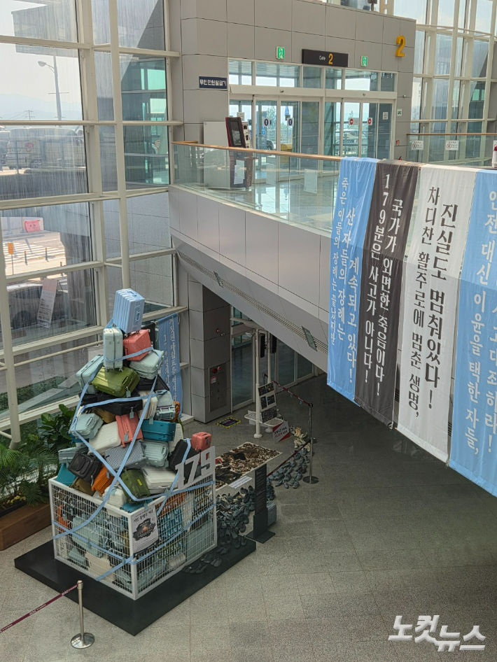 23일 무안국제공항 내부에 12·29 제주항공 여객기 참사 희생자들을 추모하는 조형물과 진상규명을 촉구하는 현수막이 설치돼 있다. 정유철 기자