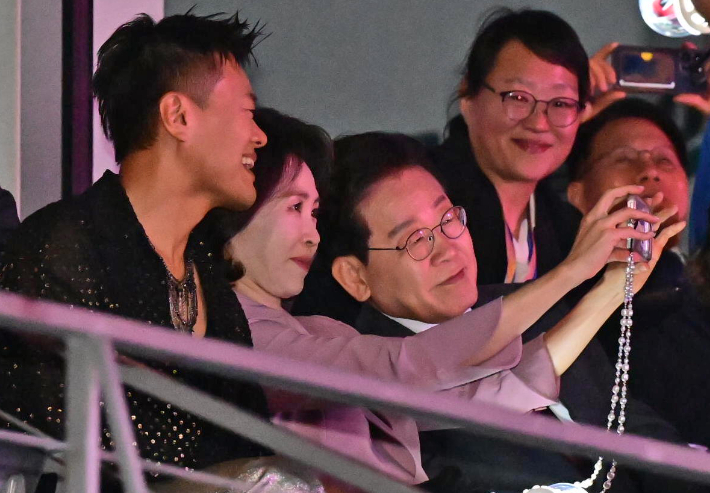 이재명 대통령과 김혜경 여사가 25일(현지시간) 멕시코시티 GNP 스타디움에서 열린 스트레이시티 콘서트에서 대중문화교류위원회 공동위원장인 박진영 JYP엔터테인먼트 대표 프로듀서와 기념촬영을 하고 있다. 연합뉴스