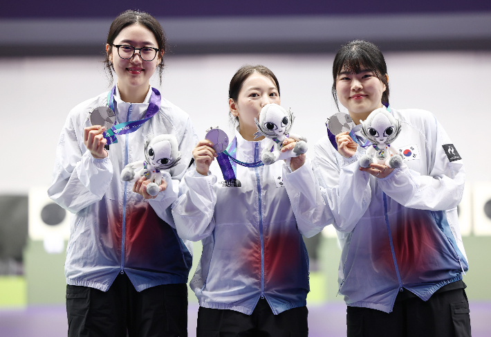 28일 일본 아이치현 종합사격장에서 열린 2026 아이치·나고야 아시안게임 사격 여자 25ｍ 권총 단체전 시상식. 은메달을 획득한 한국 대표팀이 메달을 들어보이고 있다. 사진 왼쪽부터 양지인, 봉서린, 오예진. 연합뉴스