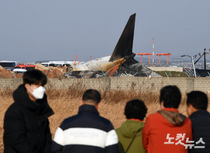 무안국제공항에서 탑승객 181명을 태운 여객기가 착륙 중 활주로를 이탈해 사고가 발생한 지난 2024년 12월 29일 주민들이 사고현장을 바라보고 있다. 황진환 기자