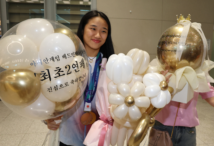 아시안게임 배드민턴 여자 단식 사상 첫 2연패를 달성한 배드민턴 '세계 최강' 안세영이 30일 인천국제공항 제2여객터미널을 통해 귀국해 팬으로부터 받은 선물을 들고 기념 촬영을 하고 있다. 연합뉴스 