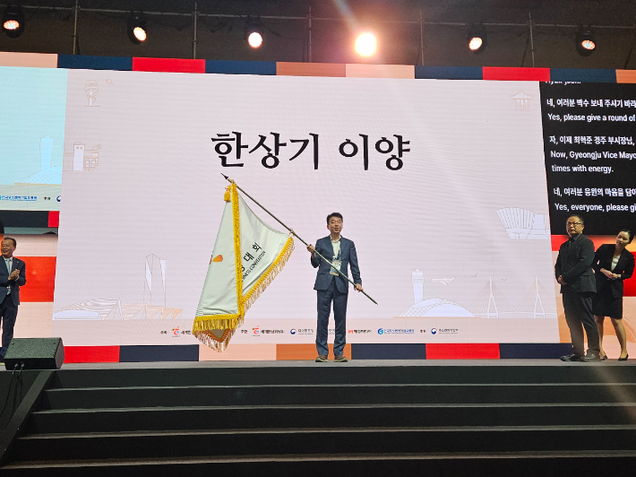 최혁준 경주시부시장이 2027년 제25차 세계한상대회 경주 개최 한상기를 이양받고 있다. 경주시 제공