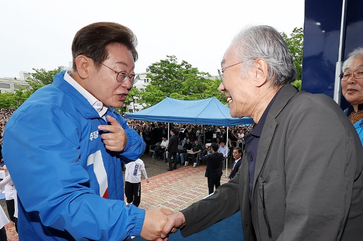지난해 5월 16일 이재명 대통령이 더불어민주당 대선 후보로 활동할 때 전북 군산시 구시청광장에서 열린 유세에서 황석영 작가와 악수하고 있다. 연합뉴스