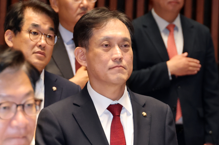 국민의힘 김태규 의원이 1일 국회 예결위 회의장에서 열린 의원총회에서 국기에 경례하고 있다. 연합뉴스