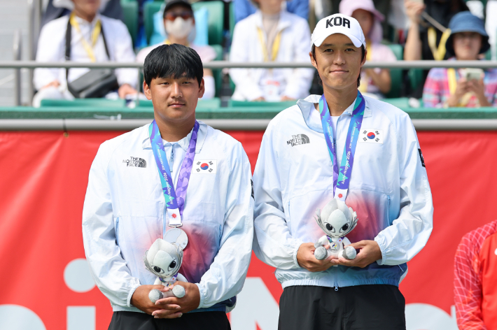 2일 일본 나고야 히가시야마 공원 테니스센터에서 열린 2026 아이치·나고야 아시안게임 테니스 남자 복식 결승에서 은메달을 차지한  대한민국 남지성(오른쪽)과 박의성이 메달을 목에 걸고 기념 촬영을 하고 있다. 연합뉴스 