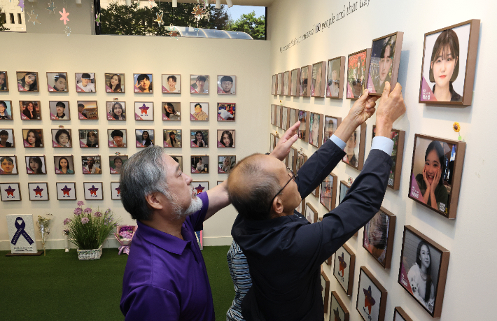 1일 서울 종로구 적선현대빌딩에 마련된 별들의 집에서 열린 10·29이태원참사 4주기 '기억과 애도의 날' 선포 기자회견에서 160번째 희생자 고 백형준씨 가족이 고인의 사진 액자를 걸고 있다. 연합뉴스