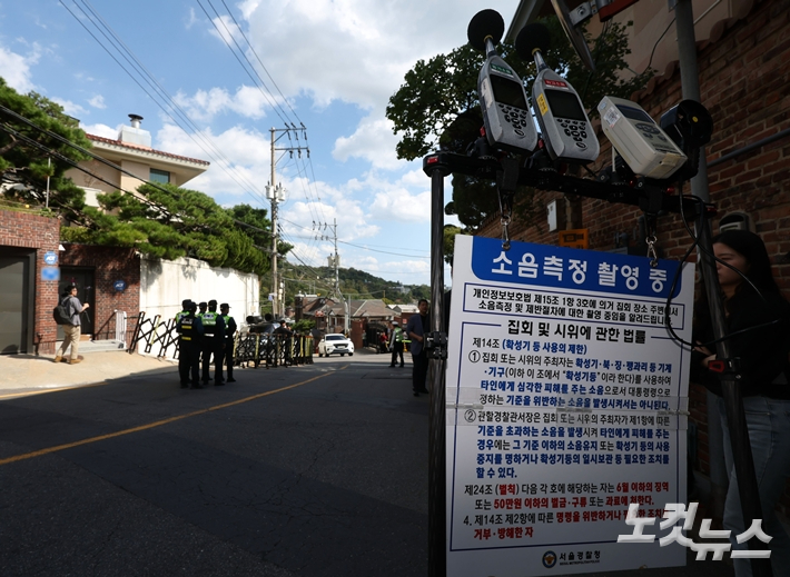 유해진 주거지로 알려진 서울 성북구 주택 앞에서 열린 규탄 시위 현장에 경찰의 소음 측정 장비가 설치된 모습. 황진환 기자