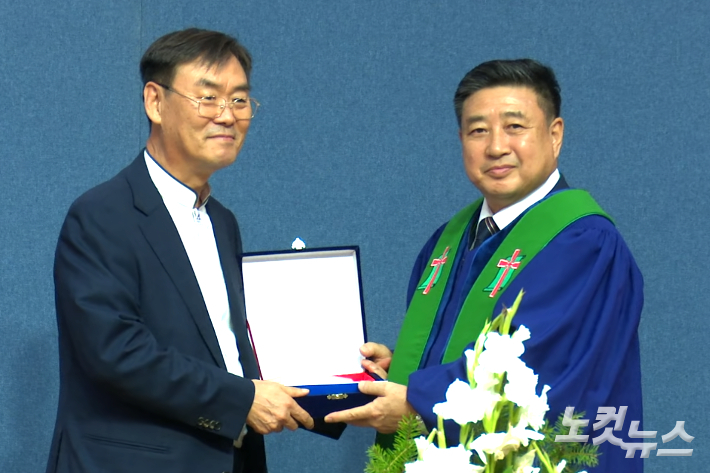 신임 노회장이 전 노회장에게 공로패를 전달하고 있다. 충북CBS