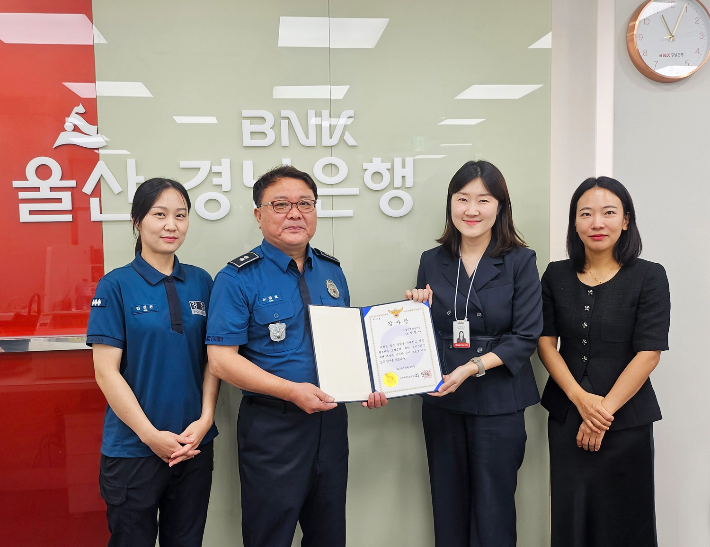 BNK경남은행 화봉동지점 직원들(오른쪽)이 보이스피싱 피해를 예방한 공로로 울산북부경찰서 관계자로부터 감사장을 받고 있다. BNK경남은행 제공