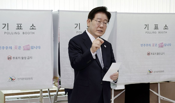 이재명 대통령이 제9회 전국동시지방선거 사전투표 첫날인 29일 서울 종로구 삼청동 주민센터에서 사전 투표 중 기표 도장 관련 문의를 하고 있다. 연합뉴스