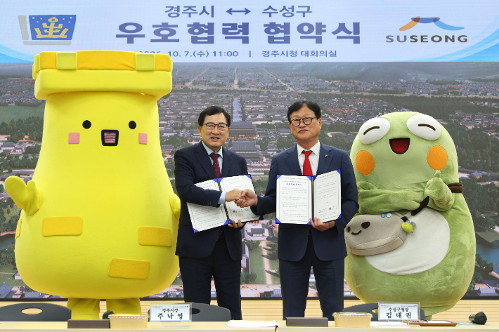 주낙영 경주시장과 김대권 수성구청장이 7일 경주시청에서 우호협력 협약식 후 기념품을 들고 기념촬영을 하고 있다. 경주시 제공