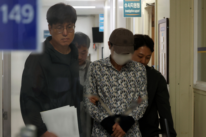 60대 부부를 살해한 혐의로 긴급체포된 50대 A씨가 8일 오전 광주 동부경찰서에서 전남 나주경찰서로 호송되고 있다. 연합뉴스