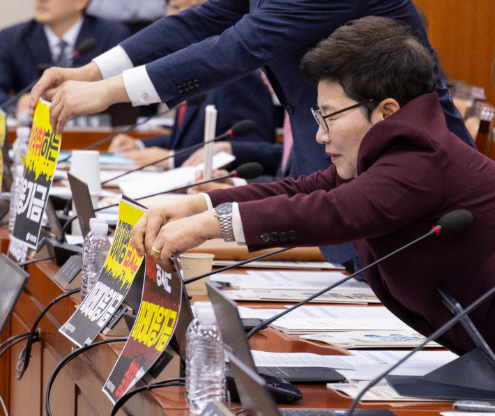 국민의힘 임이자 정책위의장을 비롯한 재정경제기획위원들이 8일 국회에서 열린 기획예산처 국정감사 시작 직전 정부가 추진중인 '미래대응기금' 반대가 담긴 인쇄물을 노트북에 붙이고 있다. 연합뉴스