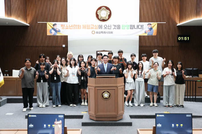 지난 8월 의정체험에 참여한 학생들이 이계철 화성시의회장(사진 가운데)과 함께 기념사진을 촬영하고 있다. 화성시의회 제공
