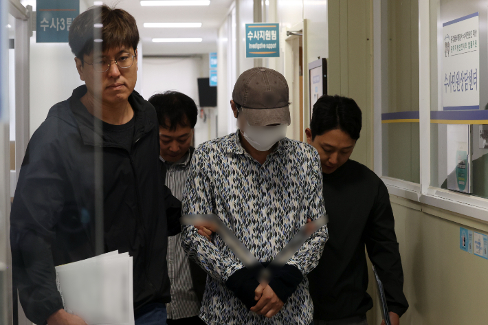 60대 부부를 살해한 혐의로 긴급체포된 50대 A씨가 8일 오전 광주 동부경찰서에서 전남 나주경찰서로 호송되고 있다. 연합뉴스