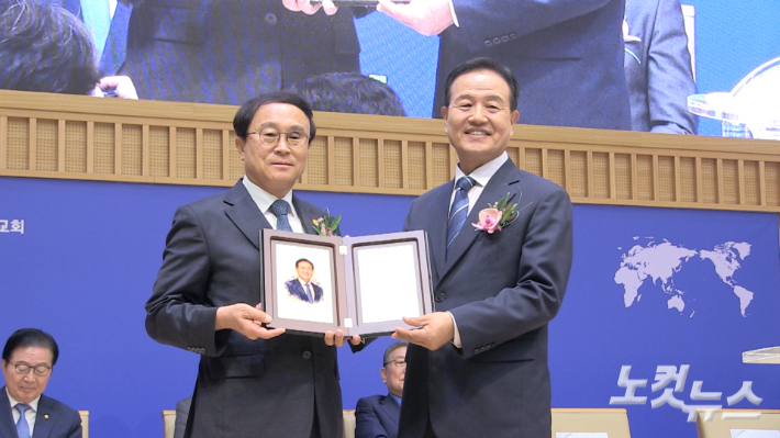 기독교한국침례회 제82대 총회장 이취임 감사예배에서 제81대 최인수 직전 총회장이 제82대 김선배 신임 총회장에게 취임 축하패를 전달하고 있다. 이바울 기자
