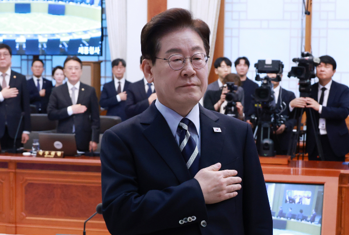 이재명 대통령이 13일 청와대에서 열린 국무회의에서 국기에 경례하고 있다. 연합뉴스