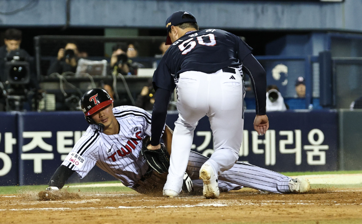 14일 서울 잠실야구장에서 열린 2026 신한 SOL KBO 포스트시즌 와일드카드 결정전 1차전 두산 베어스와 LG 트윈스의 경기. 8회말 2사 1, 2루 LG 박해민 타석 때 1루 주자 이영빈이 폭투를 틈타 홈으로 쇄도하다 두산 이영하에게 태그아웃되고 있다. 연합뉴스